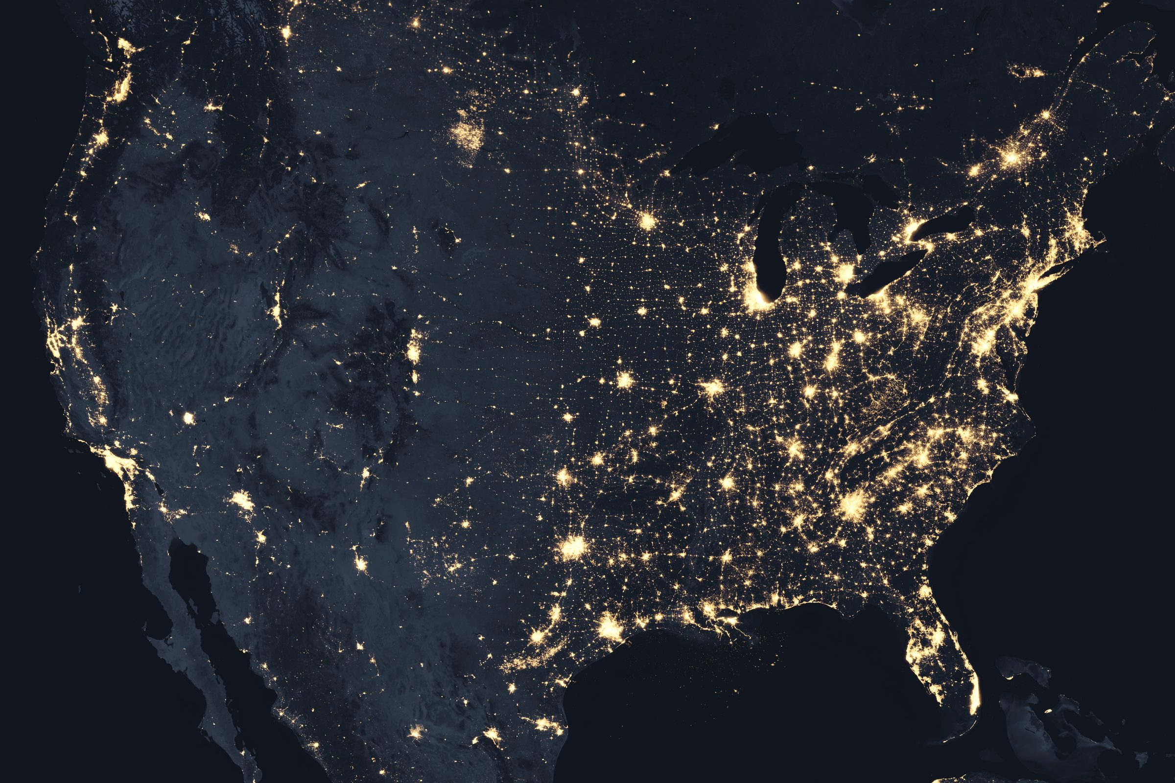 Satellite composite of the continental United States at night, with city lights glowing