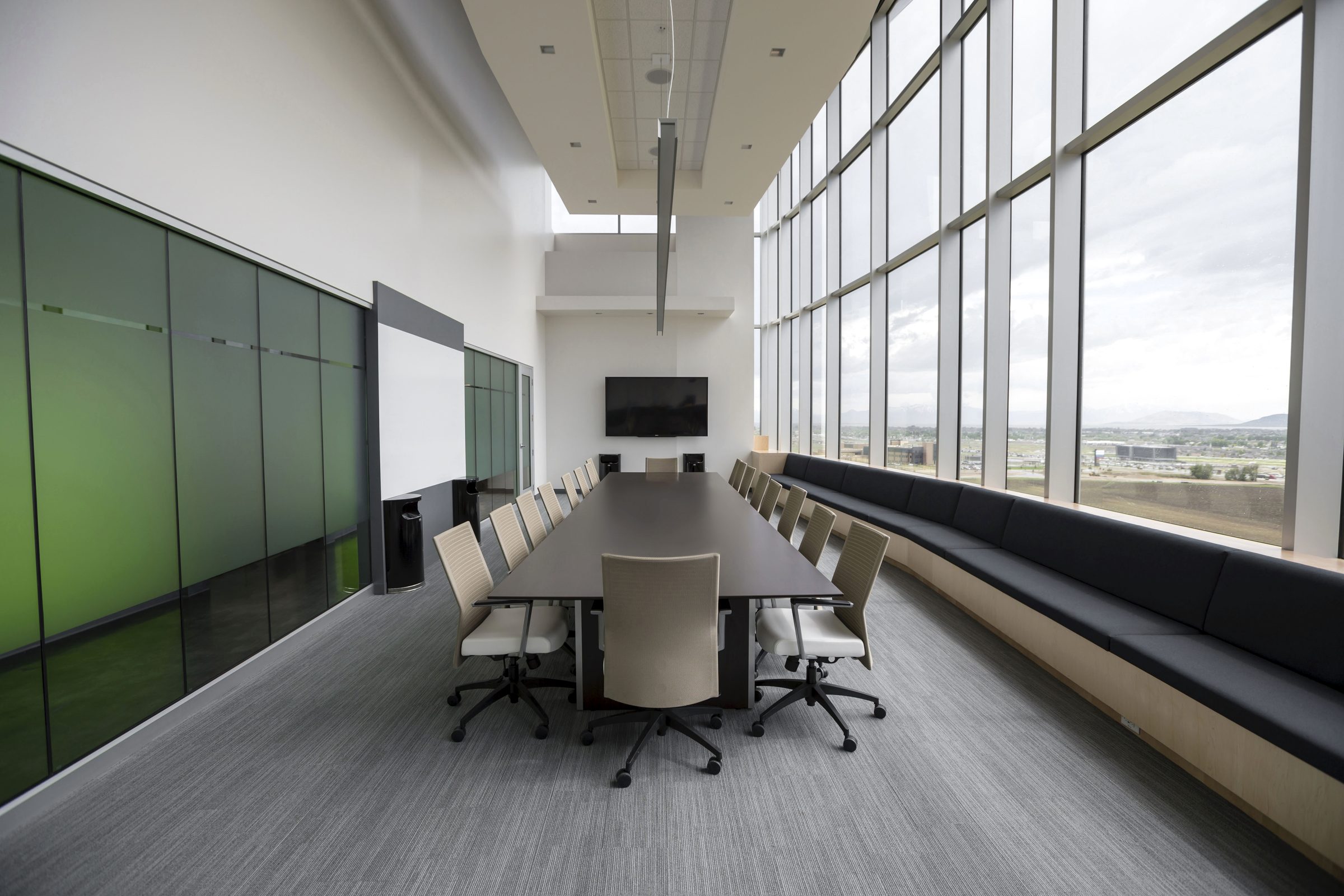 A quiet modern boardroom with a long table and floor-to-ceiling windows